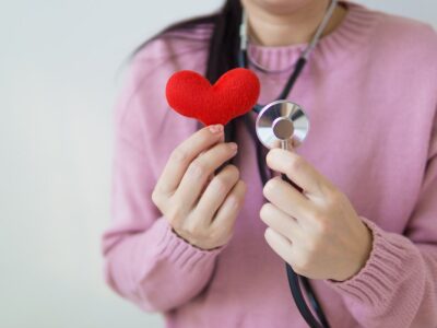 woman holding heart and stethoscope; heart health concept