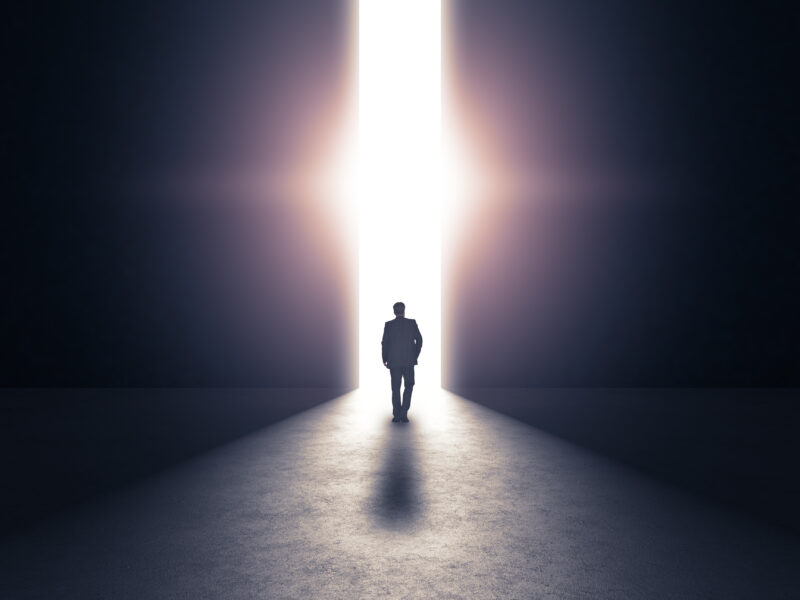 Man walking through shadow towards light concept.