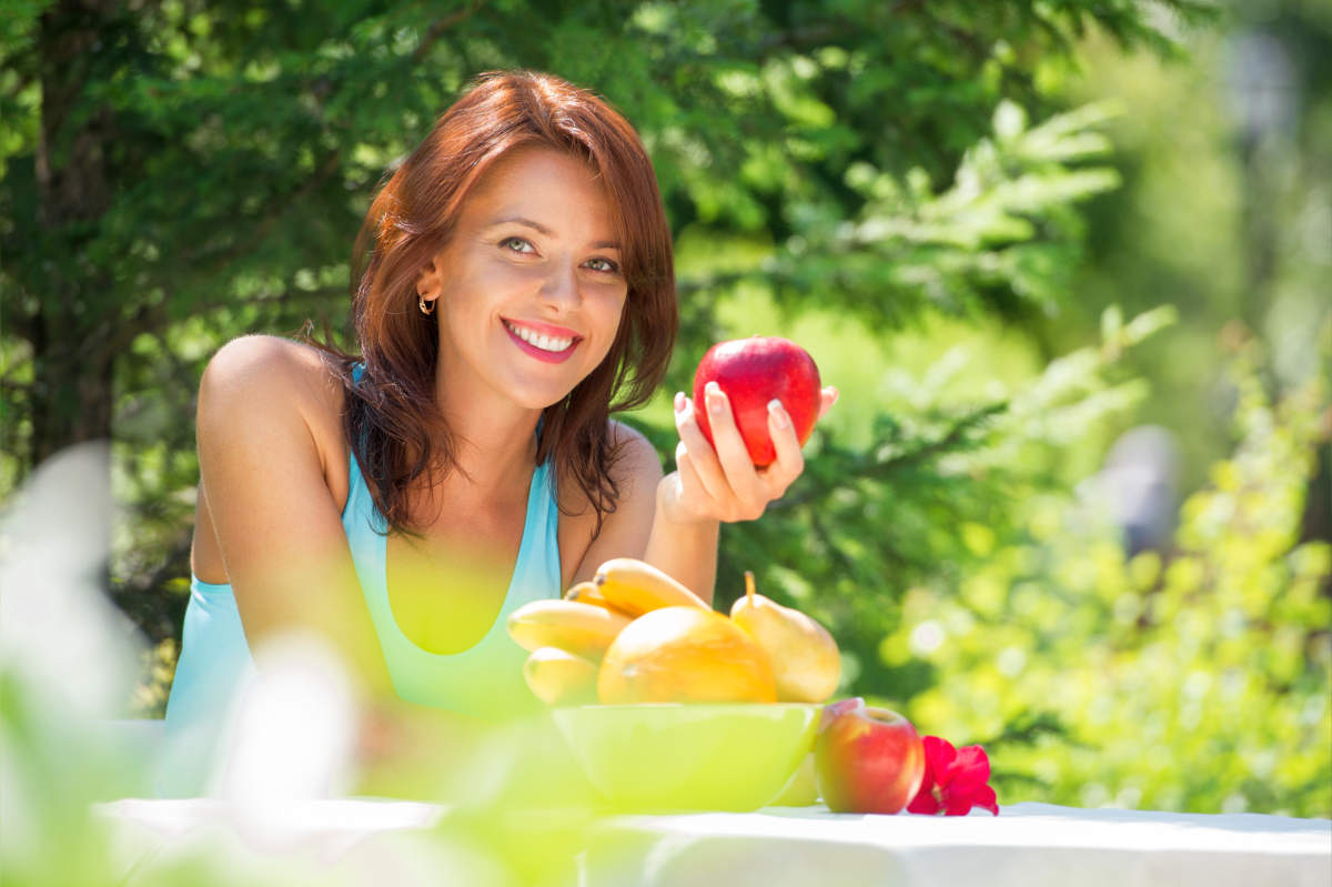 Happy smiling young woman eating organic | How Is Trimethylamine Produced And What Should You Know About It