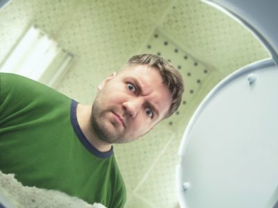 photo of man looking in toilet bowl