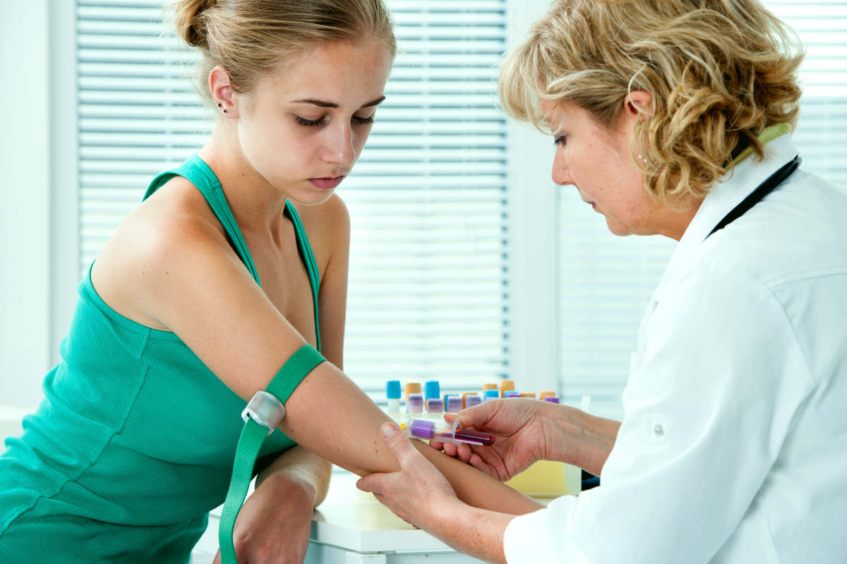 Nurse taking blood sample from patient at the doctors office | Can Too Much Iron Cause Inflammation?
