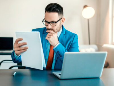 photo of young businessman reading document at office desk with focus
