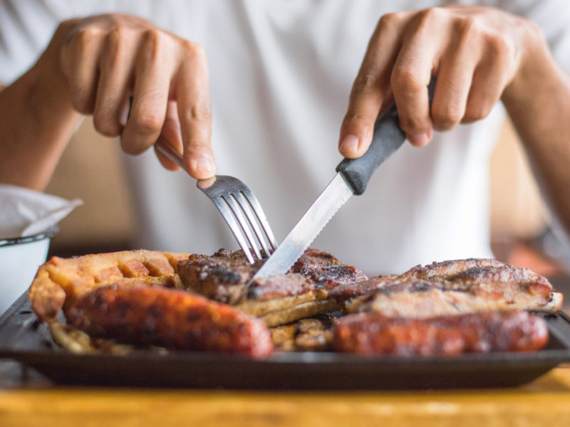 photo of man eating grilled meats, too much protein