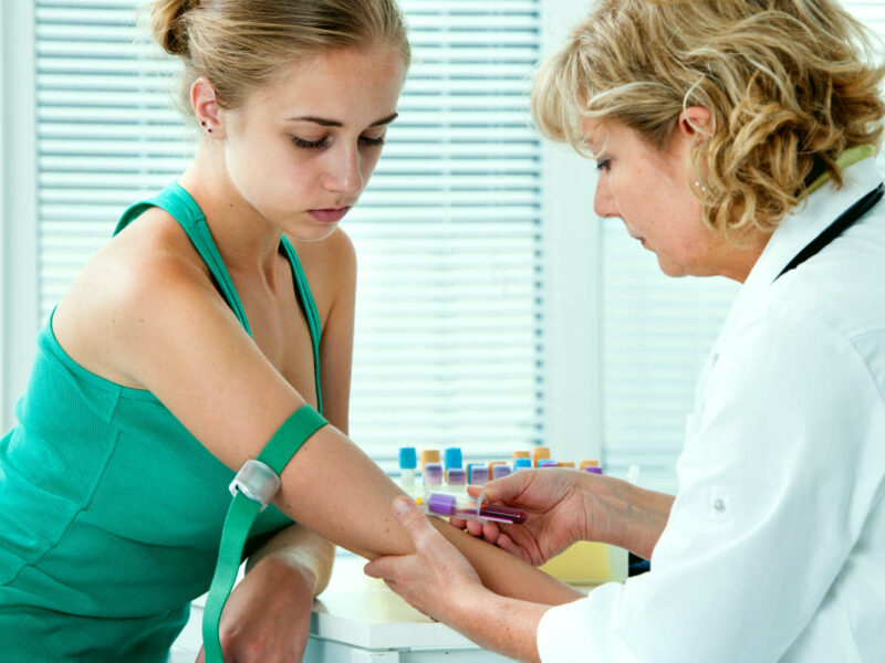 nurse taking blood sample from patient to test for too much iron