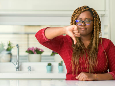 photo of a woman in her kitchen giving a thumbs down
