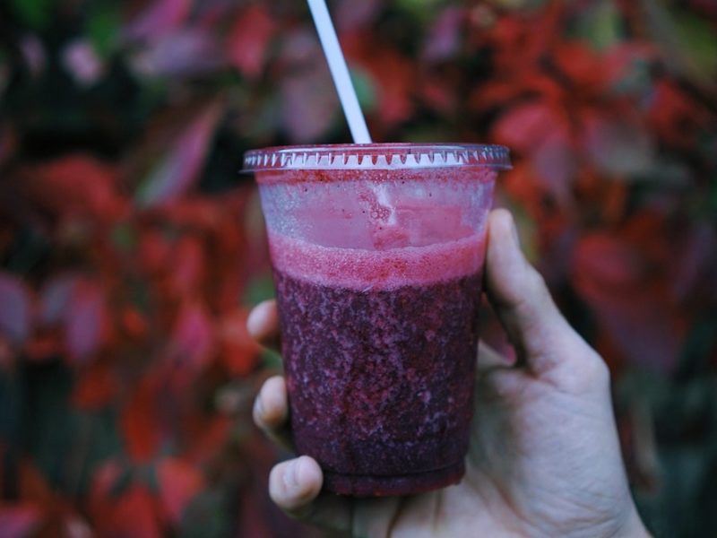 photo of person holding a berry smoothie