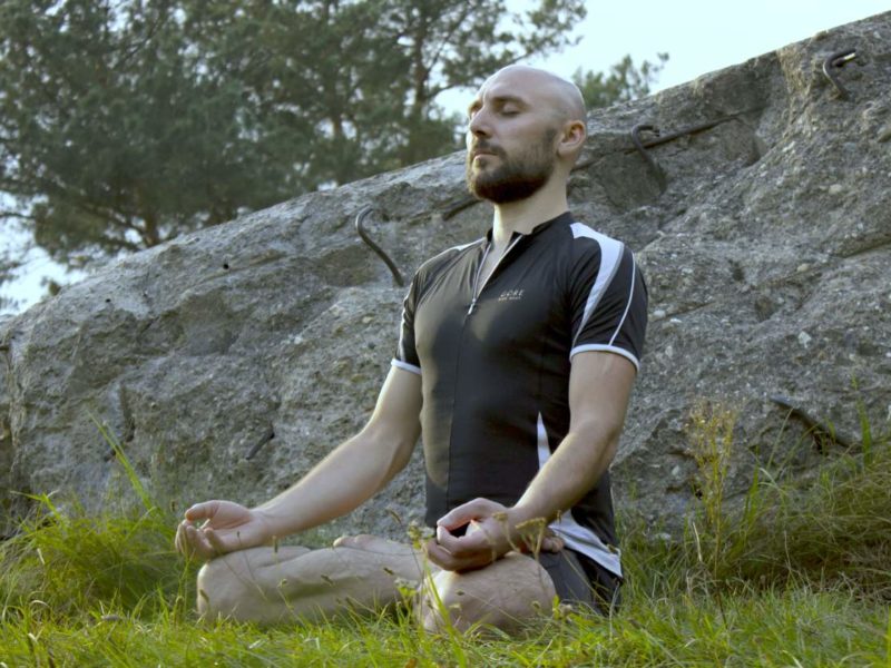 photo of man meditating outdoors