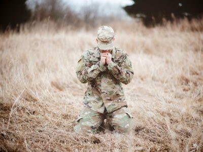 Soldier praying in a field