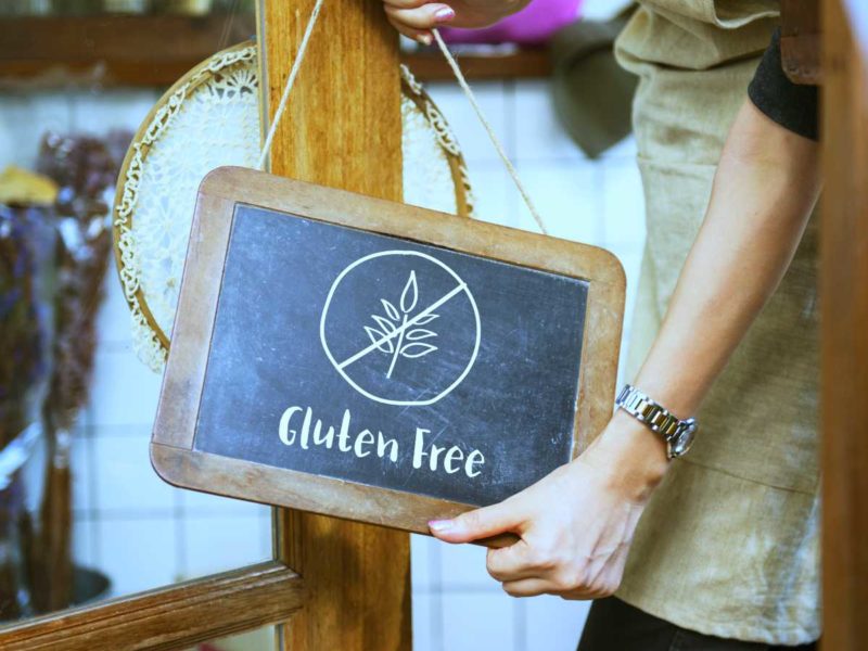 Woman holding gluten-free chalkboard sign