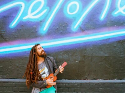 musician playing in front of a neon wall