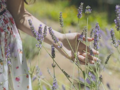 stress-free woman touching purple flowers in a field