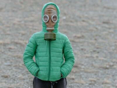 child wearing gas mask in deserted field to protect from environmental toxins