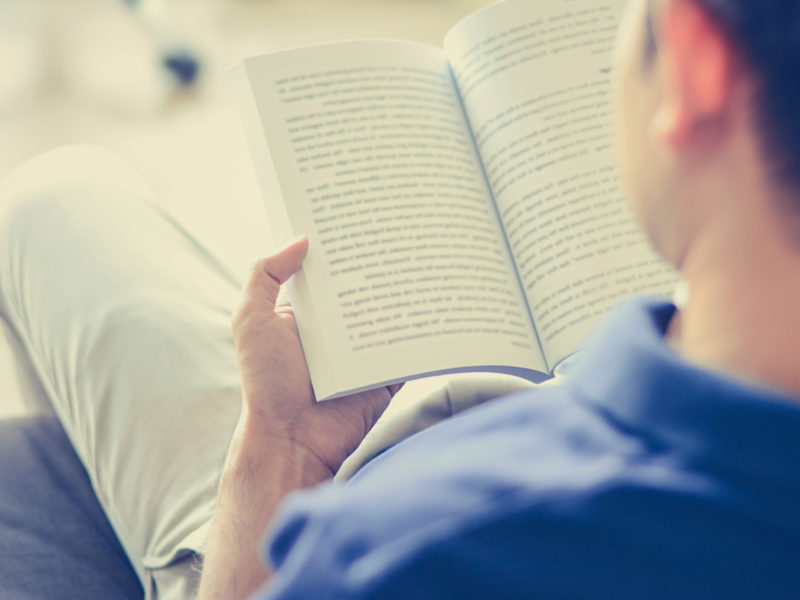 photo of man reading Cognitive Behavioral Therapy book