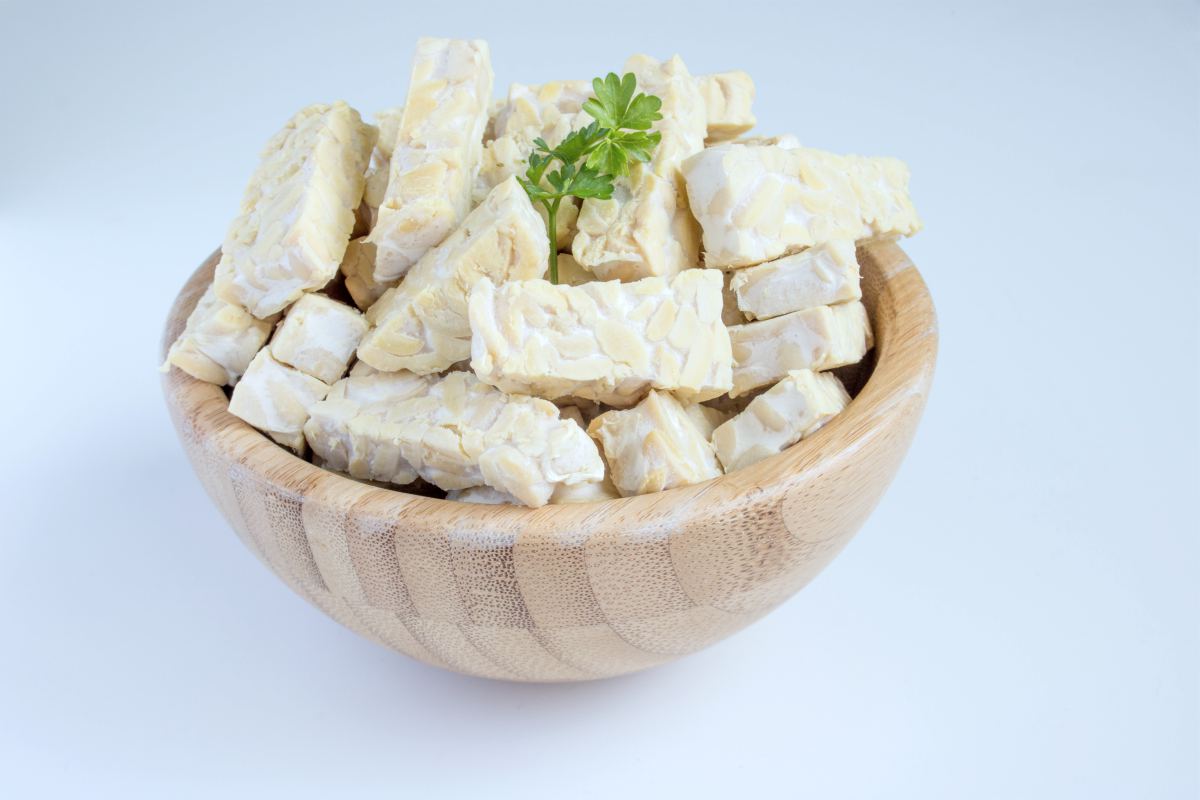 sliced raw tempeh on a wooden bowl | vegan probiotics | probiotics vegan | vegan probiotics whole foods