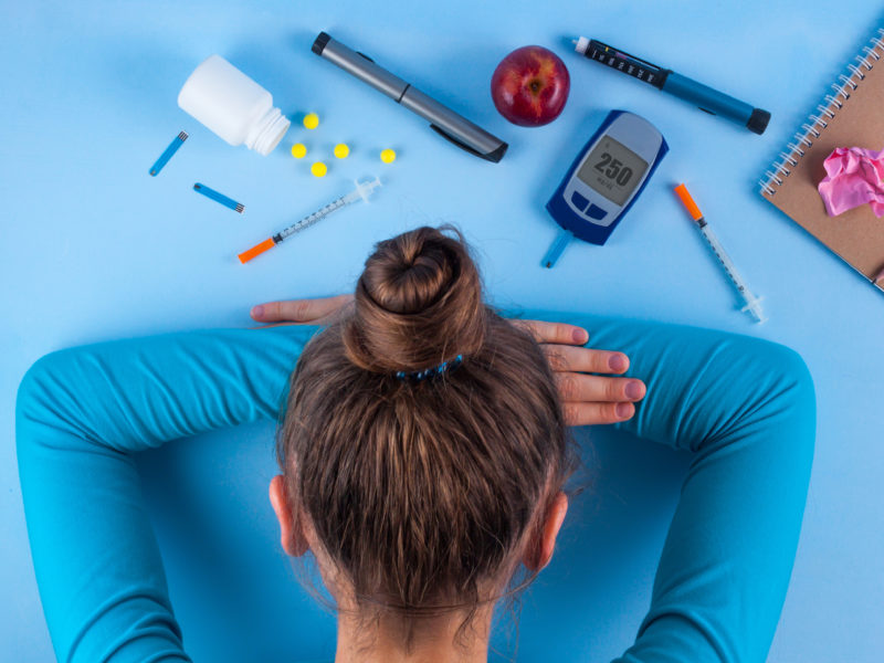 photo of frustrated diabetic woman with head down on table