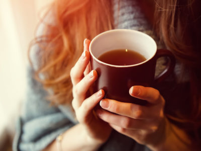 photo of woman holding cup of tea