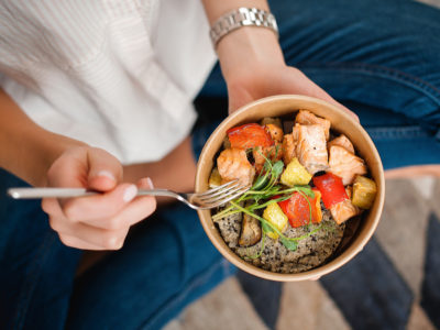 woman holding bowl of healthy foods