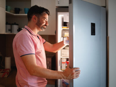 man with cravings looking in fridge for a late night snack