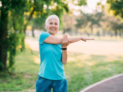 mature woman stretching outdoors to improve mobility
