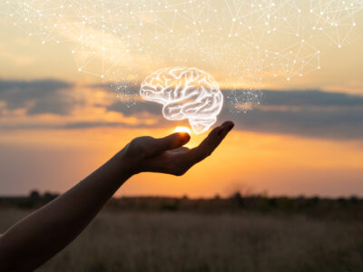 Hand shows the brain in the sun and sky, brain health concept