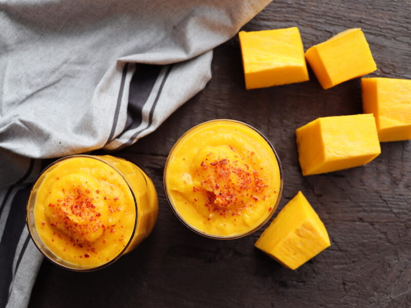 Pumpkin smoothie with spices on a wooden background.