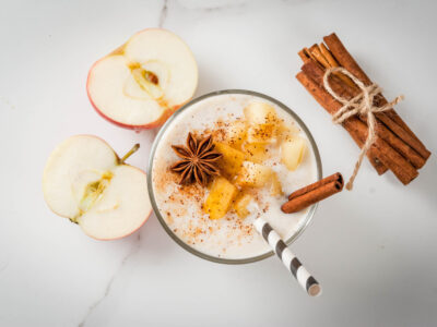 Healthy vegan food. Dietary breakfast or snack. Apple pie smoothies, with apples, yogurt, cinnamon, spices, walnuts. In a glass, on a white marble table.