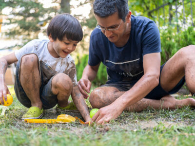 photo of father and son playing in the dirt having fun