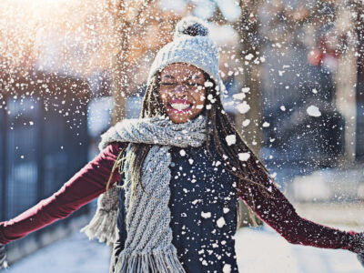 Photo of young woman playing in the snow