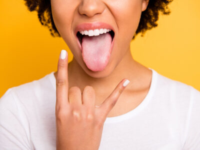 Young healthy woman with her tongue out; oral microbiome concept