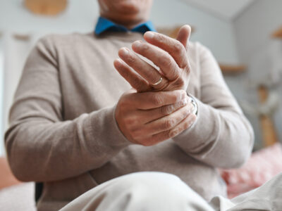 photo of man with hand and finger joint pain from arthritis