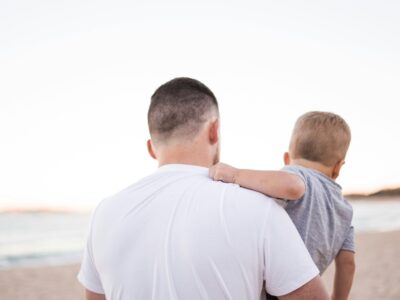 man with dad bod metabolism at the beach holding toddler